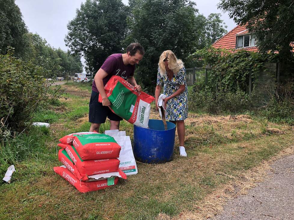 Melkveehouder Wilco Brouwer de Koning en gedeputeerde Esther Rommel (Natuur en Landschap) mengen de kruidenrijke zaden.