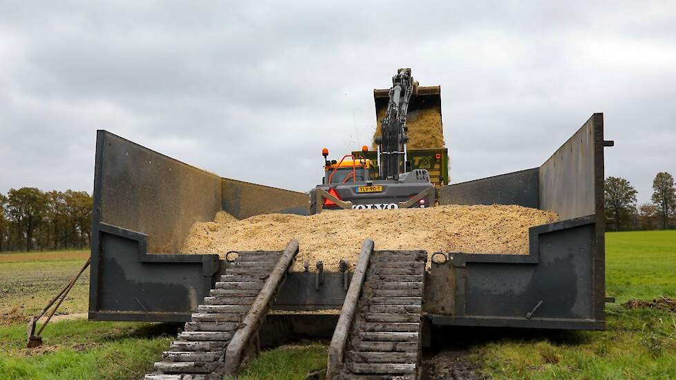 De rupsdumper lossen in een bak op de kopakker.